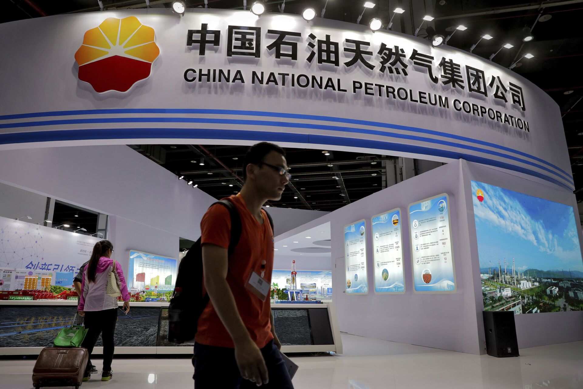 In this Sept. 21, 2016, photo, visitors walk by the China National Petroleum Corporation (CNPC) exhibition booth during the China International Chemical Industry Fair in Shanghai, China. - Sputnik International, 1920, 08.03.2022
