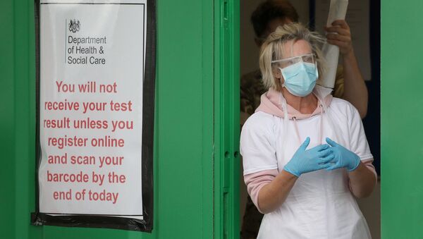 A staff member is pictured next to a banner at a COVID-19 testing centre amid the coronavirus disease outbreak, at Glasgow Airport, in Glasgow, Scotland April 29, 2020.  - Sputnik International