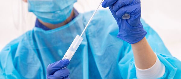 A medical staff wearing protective gear administers tests for the coronavirus disease (COVID-19) at a test facility, in a tent outside the Skane University Hospital in Lund, Sweden. A medical staff wearing protective gear administers tests for the coronavirus disease (COVID-19) at a test facility, in a tent outside the Skane University Hospital in Lund, Sweden. - Sputnik International