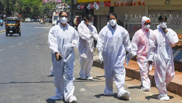 Healthcare workers wearing Personal Protective Equipment (PPE) walk out of a hospital during a government-imposed nationwide lockdown as a preventive measure against the COVID-19 coronavirus, in Mumbai on May 4, 2020. - Sputnik International