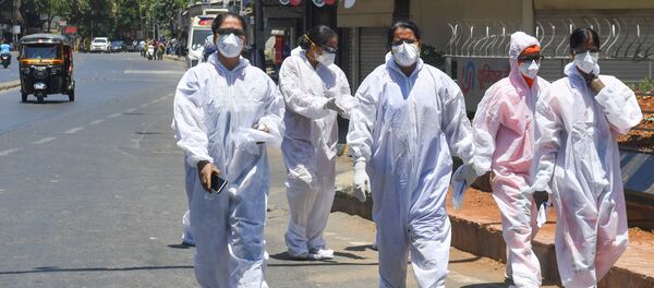 Healthcare workers wearing Personal Protective Equipment (PPE) walk out of a hospital during a government-imposed nationwide lockdown as a preventive measure against the COVID-19 coronavirus, in Mumbai on May 4, 2020. - Sputnik International