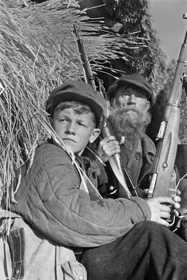 Partisans on patrol. 13-year-old Lenya Fedorov and a farmer from the Borets collective farm, Grishin, who joined the partisan detachment despite his advanced age. The Soshikhinsky district of the Leningrad region, June 1943. - Sputnik International