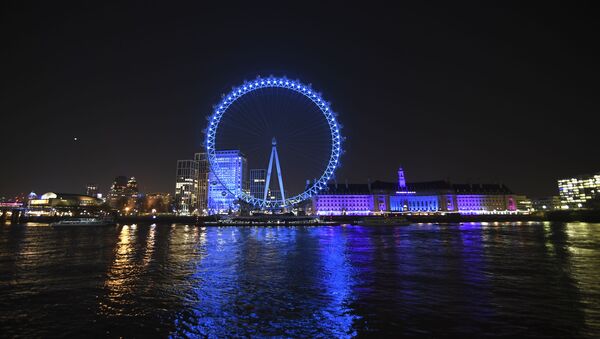 The London Eye lit up with blue light in support of British National Health Service workers who are treating coronavirus victims, as part of a nationwide salute to the doctors, nurses and staff of the NHS in London, Thursday, March 26, 2020 - Sputnik International