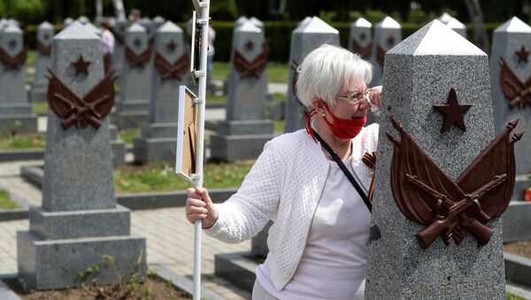 A woman mourns at a grave of a Russian soldier at the Olsany cemetery to commemorate the 75th anniversary of the end of World War Two in Prague, Czech Republic, May 8, 2020 - Sputnik International