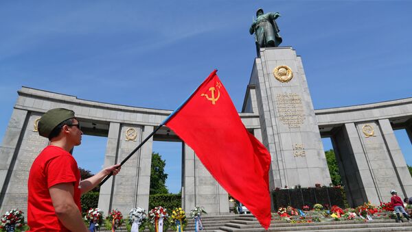 A man with a Soviet flag attends a celebration to mark Victory Day and the 75th anniversary of the end of World War Two at the Soviet War Memorial at Tiergarten Park in Berlin, Germany, May 8, 2020 - Sputnik International