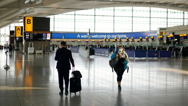 A woman wearing a mask is seen at Heathrow airport, London, Britain, April 5, 2020. - Sputnik International