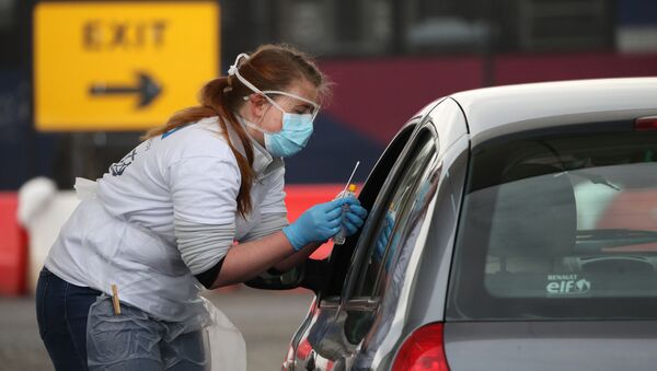 A medical worker tests a key worker for the novel coronavirus Covid-19 at a drive-in testing centre at Glasgow Airport on 29 April 2020, as the UK continues in lockdown to help curb the spread of the coronavirus. - Sputnik International