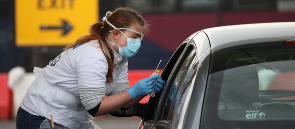 A medical worker tests a key worker for the novel coronavirus Covid-19 at a drive-in testing centre at Glasgow Airport on April 29, 2020, as the UK continues in lockdown to help curb the spread of the coronavirus. A medical worker tests a key worker for the novel coronavirus Covid-19 at a drive-in testing centre at Glasgow Airport on April 29, 2020, as the UK continues in lockdown to help curb the spread of the coronavirus. - Sputnik International