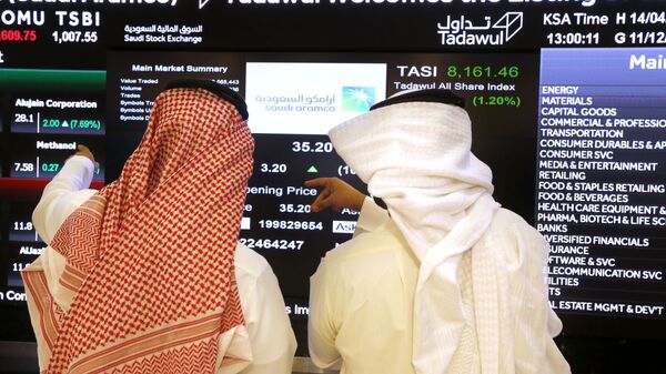 Saudi stock market officials watch the market screen displaying Saudi Arabia's state-owned oil company Aramco after the debut of Aramco's initial public offering (IPO) on the Riyadh's stock market in Riyadh, Saudi Arabia, Wednesday, Dec. 11, 2019 - Sputnik International