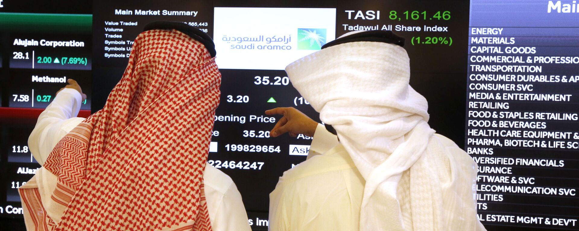 Saudi stock market officials watch the market screen displaying Saudi Arabia's state-owned oil company Aramco after the debut of Aramco's initial public offering (IPO) on the Riyadh's stock market in Riyadh, Saudi Arabia, Wednesday, Dec. 11, 2019 - Sputnik International, 1920, 04.06.2023