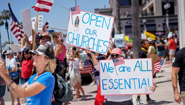 People gather near Huntington Beach Pier to protest Gov. Gavin Newsom?s order to temporarily close state and local beaches in Orange County, during the outbreak of the coronavirus disease (COVID-19), in Huntington Beach, California, U.S., May 1, 2020 - Sputnik International