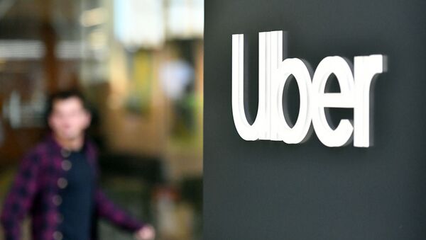 An Uber logo is seen on a sign outside the company's headquarters location as people protest nearby in San Francisco, California on May 8, 2019 - Sputnik International