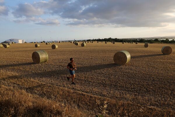 A man runs in a field on the first day of the easing of the nationwide lockdown against the spread of the coronavirus disease (COVID-19), in Larnaca, Cyprus, 4 May 2020.  - Sputnik International