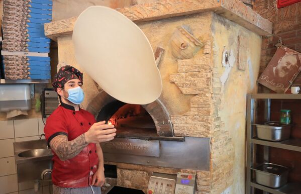 Pizza chef Carmelo la Ciura prepares food in the restaurant Tuscolo that reopened today, following weeks of closure due to the global outbreak of the coronavirus disease (COVID-19), in Bonn, Germany, 11 May 2020.  - Sputnik International