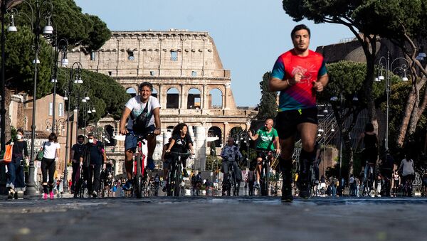 People jog or ride along Via dei Fori Imperiali in central Rome on May 10, 2020 during the country's partial lockdown aimed at curbing the spread of the COVID-19 infection, caused by the novel coronavirus.  - Sputnik International