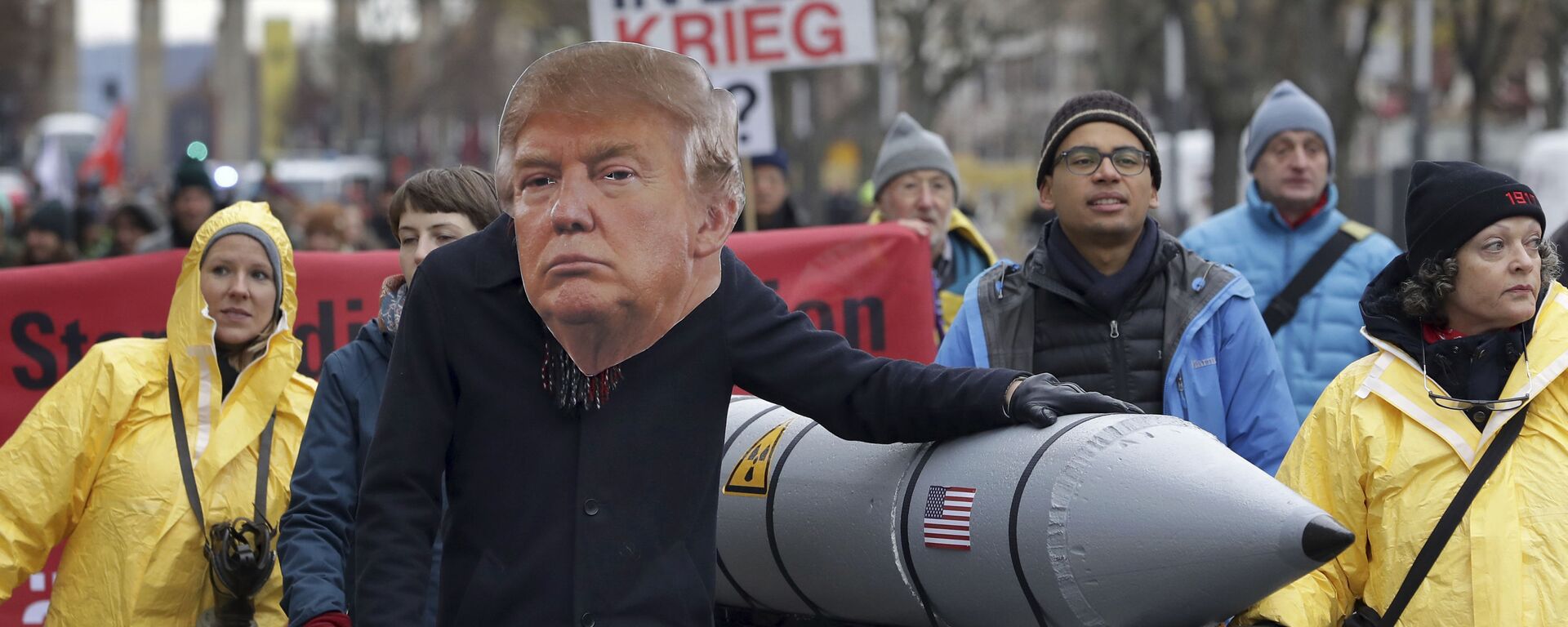 یک معترض ضد جنگ در روز شنبه، 18 نوامبر 2017، در برلین، آلمان، در جریان تظاهرات ضد هسته‌ای در نزدیکی دروازه براندنبورگ، ماسکی را به تصویر می‌کشد که دونالد ترامپ، رئیس‌جمهور آمریکا را به تصویر می‌کشد - Sputnik International 1920 02/29/2024
