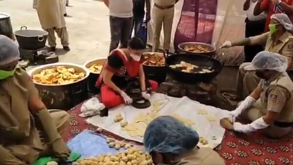 Sapna Choudhary, known for setting the stage on fire, roll 'Pooris' for the needy at Najafgarh Police station. She appreciated the female personnel for their service - Sputnik International
