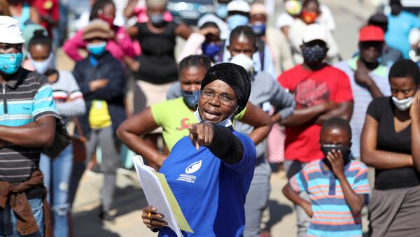 A woman gestures as she holds a book with names of recipients during food distribution, as South Africa starts to relax some aspects of a stringent nationwide coronavirus disease (COVID-19) lockdown, in Diepsloot near Johannesburg, South Africa, May 8, 2020 - Sputnik International