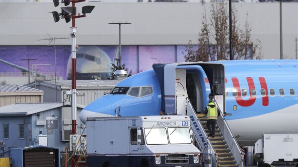 A worker walks up steps to the right of an avionics truck parked next to a Boeing 737 MAX 8 airplane being built for TUI Group at Boeing Co.'s Renton Assembly Plant Wednesday, March 13, 2019, in Renton, Wash - Sputnik International