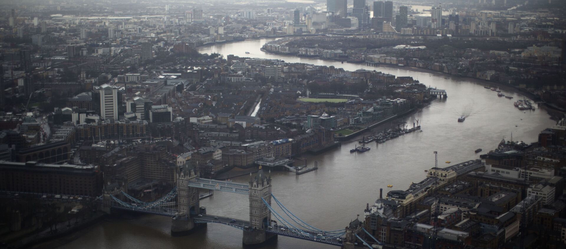 Tower Bridge, centre, and Canary Wharf in the distance with the Thames flowing through London, are seen through a window during the official opening of The View  - a viewing platform at the 95-storey Shard skyscraper in London, Friday, 1 February 2013. - Sputnik International, 1920, 12.03.2021