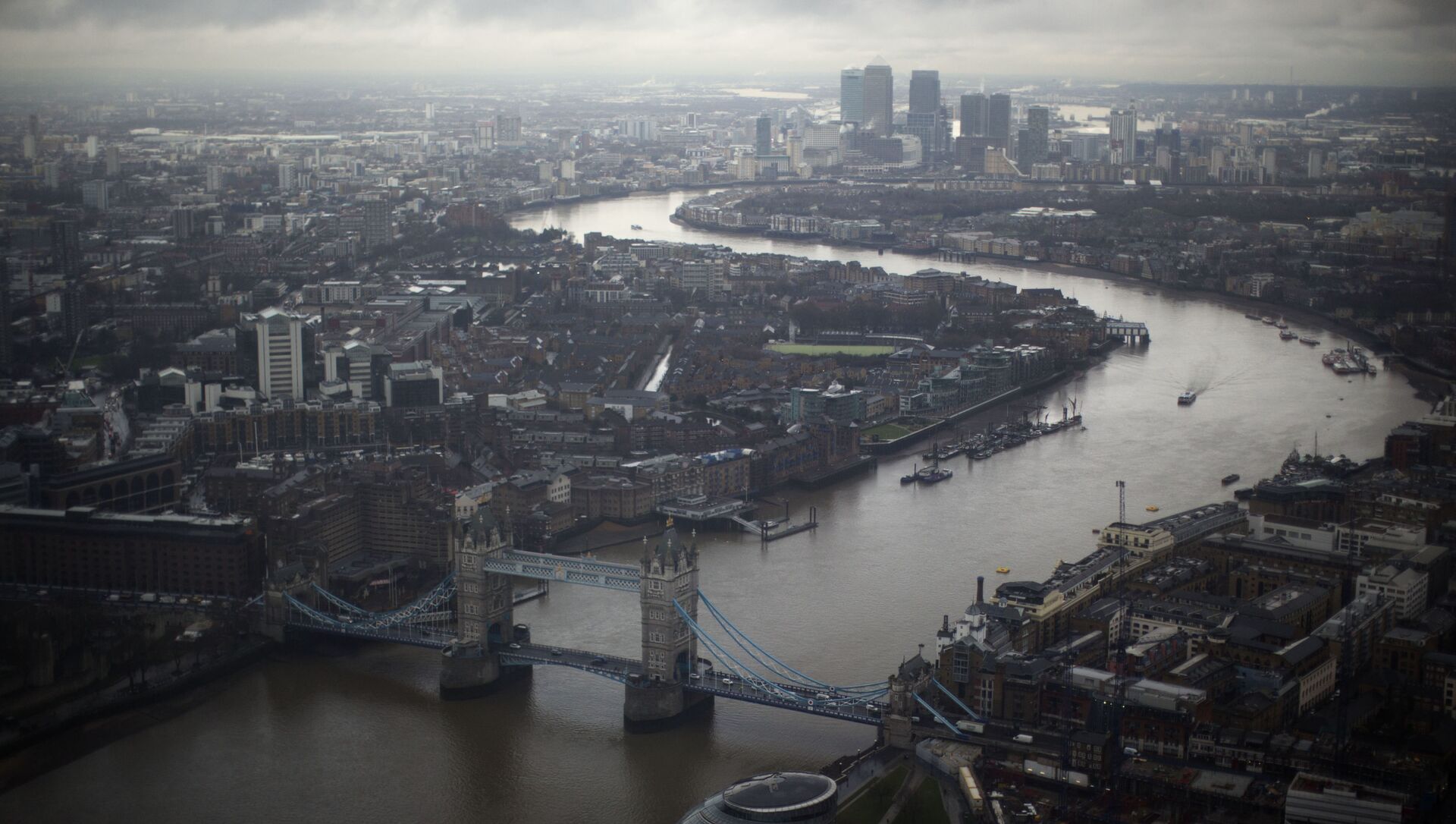 Tower Bridge, centre, and the Canary Wharf business district in the distance as the River Thames flows through London, are seen through a window during the official opening of The View viewing platform at the 95-storey Shard skyscraper in London, Friday, Feb. 1, 2013 - Sputnik International, 1920, 02.04.2021