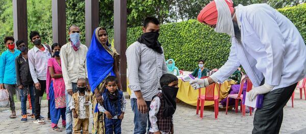 A health worker checks the body temperature of migrant workers before they go to Amritsar railway station to take a special train to Ambedkar Nagar in Uttar Pradesh state back to their hometowns after the government eased a nationwide lockdown imposed as a preventive measure against the COVID-19 coronavirus,on the outskirts of Amritsar on May 13, 2020 A health worker checks the body temperature of migrant workers before they go to Amritsar railway station to take a special train to Ambedkar Nagar in Uttar Pradesh state back to their hometowns after the government eased a nationwide lockdown imposed as a preventive measure against the COVID-19 coronavirus,on the outskirts of Amritsar on May 13, 2020 - Sputnik International