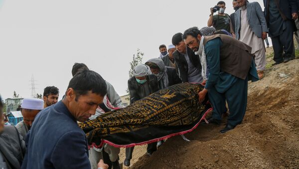 Mourners carry a covered dead body during a burial ceremony following a suicide attack in a maternity hospital, at a cemetery in Kabul on May 13, 2020. - Sputnik International