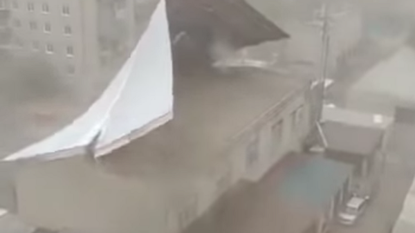 Screengrab from amateur video showing winds ripping steel building off roof in Chita, Siberia on Wednesday, May 12, 2020. - Sputnik International