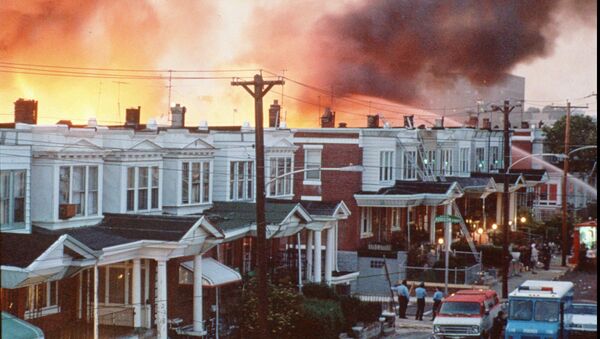 FILE--Row houses in Philadelphia burn after officials dropped a bomb on the MOVE house in this May 1985 photo from files. Ramona Africa, the lone adult survivor of the May 13, 1985 fire, and two other MOVE members sued the city of Philadelphia, and the former police and fire commissioners for financial damages in what was the first trial in court to address the MOVE bombing. The jury said Monday afternoon June 24, 1996, that it reached a verdict, but the result was not announced immediately.(AP Photo/files) - Sputnik International