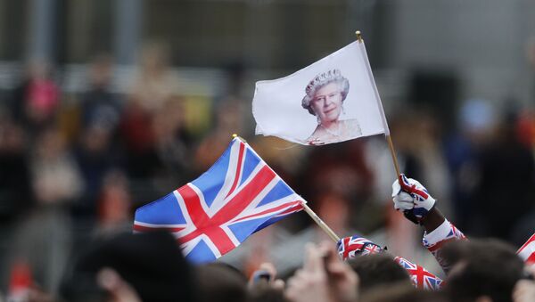 People wave a British union flag and a flag bearing the image of Britain's Queen Elizabeth II ahead of the annual Commonwealth Day service at Westminster Abbey in London, Monday, March 9, 2020 - Sputnik International