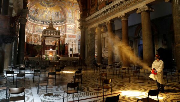 A man disinfects the Santa Maria in Trastevere Basilica, during the coronavirus disease (COVID-19) outbreak, in Rome, Italy, May 11, 2020. REUTERS/Remo Casilli  - Sputnik International