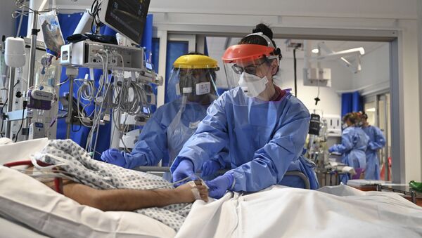 Members of the clinical staff wearing Personal Protective Equipment PPE care for a patient with coronavirus in the intensive care unit at the Royal Papworth Hospital in Cambridge, 5 May 2020 - Sputnik International
