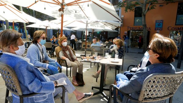 People take a coffee in a bar as some Spanish provinces are allowed to ease restrictions during the phase one, amid the coronavirus disease (COVID-19) outbreak, in Palma de Mallorca, Spain, May 11, 2020. REUTERS/Enrique Calvo - Sputnik International