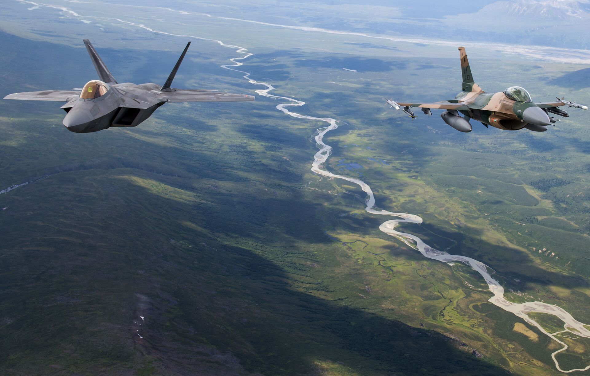 A US Air Force F-22 Raptor from Joint Base Elmendorf-Richardson and an F-16 Fighting Falcon from Eielson Air Force Base fly in formation over the Joint Pacific Alaska Range Complex, July 18, 2019 - Sputnik International, 1920, 07.02.2023