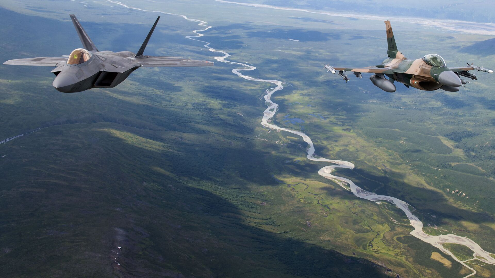 A US Air Force F-22 Raptor from Joint Base Elmendorf-Richardson and an F-16 Fighting Falcon from Eielson Air Force Base fly in formation over the Joint Pacific Alaska Range Complex, July 18, 2019 - Sputnik International, 1920, 17.09.2021