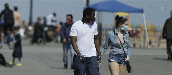 Pedestrians wear protective masks during the coronavirus pandemic while walking on the boardwalk of Coney Island Beach Friday, May 15, 2020, in the Brookyn borough of New York Pedestrians wear protective masks during the coronavirus pandemic while walking on the boardwalk of Coney Island Beach Friday, May 15, 2020, in the Brookyn borough of New York - Sputnik International