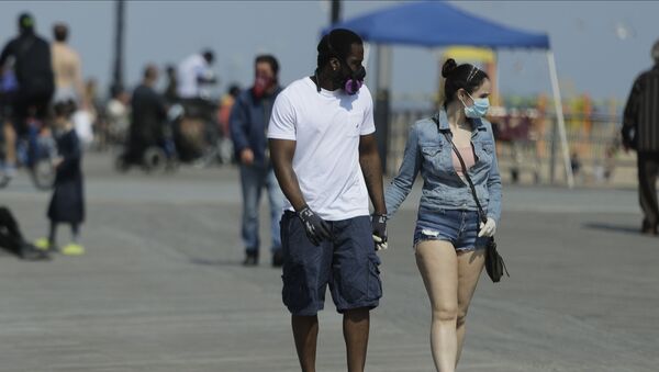 Pedestrians wear protective masks during the coronavirus pandemic while walking on the boardwalk of Coney Island Beach Friday, May 15, 2020, in the Brookyn borough of New York - Sputnik International