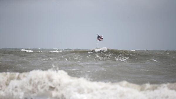 Waves crash in front of an American flag that is planted on a jetty during a high surf from the Atlantic Ocean, in advance of the potential arrival of Hurricane Dorian, in Vero Beach, Fla., Monday, Sept. 2, 2019. - Sputnik International