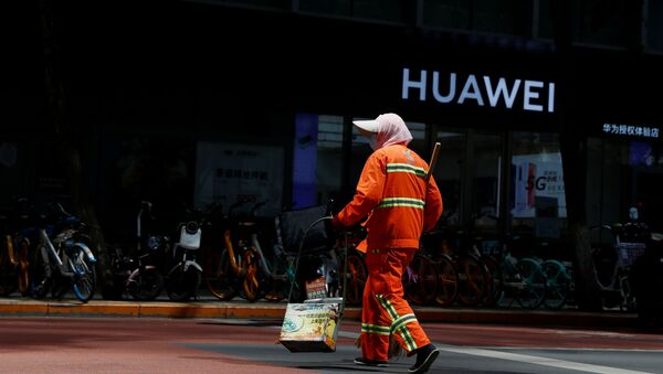 A street cleaner in a face mask walks past a Huawei shop, amid an outbreak of the coronavirus disease (COVID-19), in Beijing, China, May 18, 2020 - Sputnik International