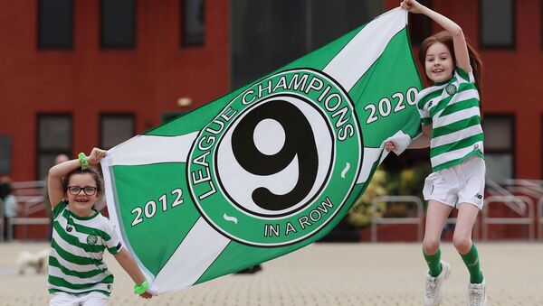 Fans are seen with a flag outside Celtic Park after Celtic were confirmed champions after the SPFL ended the season, following the outbreak of the coronavirus disease (COVID-19), Glasgow, Britain, May 18, 2020.  - Sputnik International