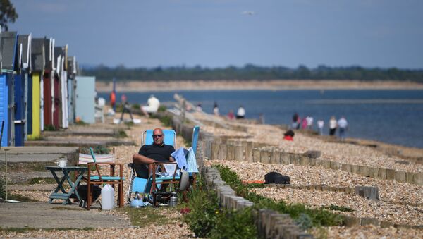 Мужчина во время отдыха на пляже в Южной Англии  - Sputnik International