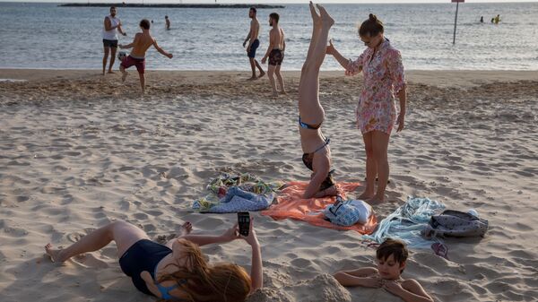 People enjoy the beach front in Tel Aviv, Israel, Saturday, May 16, 2020. Israeli authorities have recently begun loosening the restrictions of the coronavirus lockdown, the easing brought people out of their homes to enjoy the outdoors.  - Sputnik International