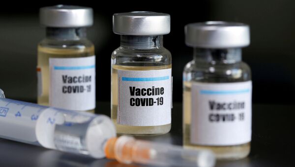 Small bottles labeled with a Vaccine COVID-19 sticker and a medical syringe are seen in this illustration taken taken April 10, 2020 - Sputnik International