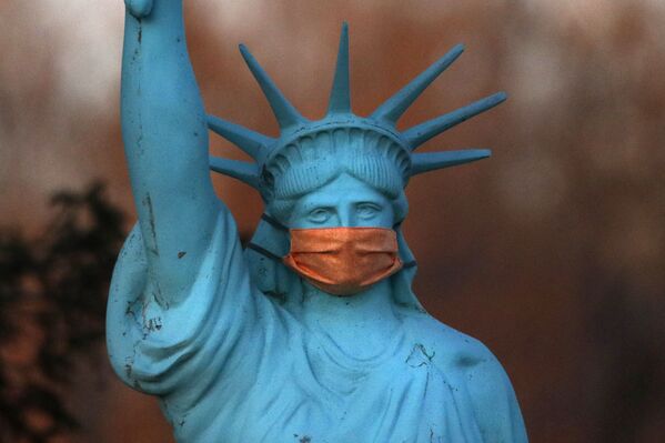 A replica of the Statue of Liberty wears a coronavirus mask outside a home on Deer Isle, Maine, 6 May 2020.  - Sputnik International