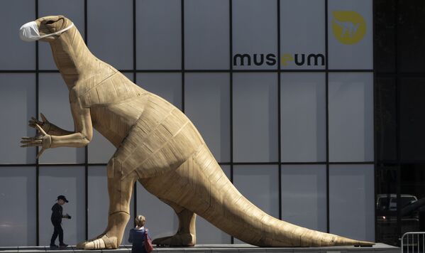 A boy walks by a model of a dinosaur wearing a face mask, during a partial lockdown to prevent the spread of the coronavirus, at the Museum of Natural History in Brussels, 19 May 2020. - Sputnik International