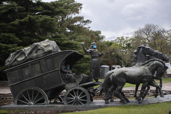 A statue of a gaucho family wearing face masks as if to prevent the spread of new coronavirus stands in Montevideo, Uruguay, 4 May 2020. The sculpture is part of a larger set which represents the pioneers in Uruguay and is called The Stage Coach. It was created by Uruguayan sculptor Jose Belloni in 1922 - Sputnik International