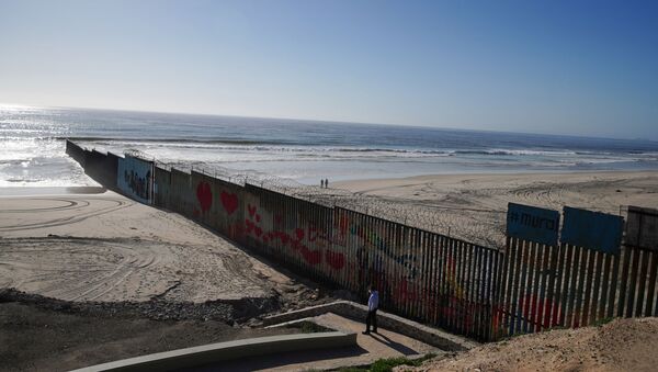 People walk on the beach and near the border wall between Mexico and the United States during the outbreak of the coronavirus disease (COVID-19), in Tijuana, Mexico, April 23, 2020. - Sputnik International