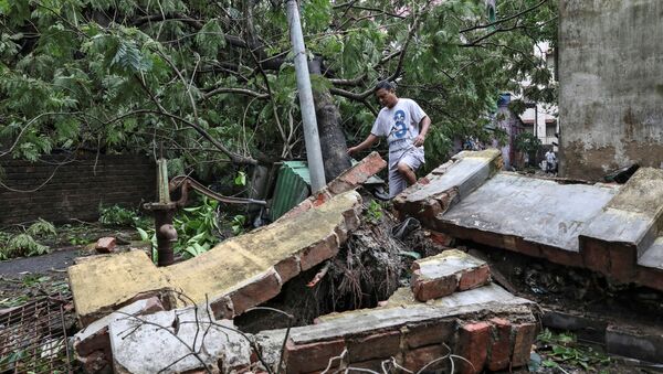 A man walks over a collapsed wall after Cyclone Amphan made its landfall, in Kolkata, India, May 21, 2020. - Sputnik International