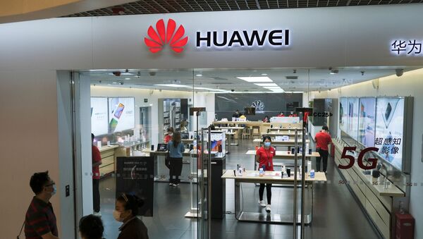 People wearing face masks walk past a?Huawei?store at a shopping mall, following an outbreak of the coronavirus disease (COVID-19), in Beijing, China May 18, 2020 - Sputnik International