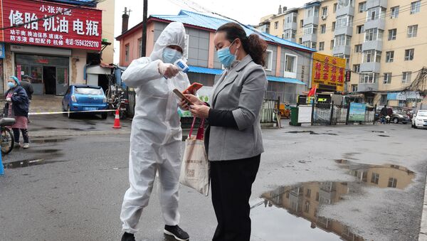 A worker in protective suit takes body temperature measurement of a woman following the coronavirus disease (COVID-19) outbreak in Jilin, Jilin province, China May 17, 2020. Picture taken May 17, 2020. cnsphoto via REUTERS   ATTENTION EDITORS - THIS IMAGE WAS PROVIDED BY A THIRD PARTY. CHINA OUT. - Sputnik International